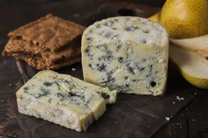 Adelost-style Swedish blue cheese wedge with blue-grey veins and rye crispbread - Adelost | KnowTheCheese