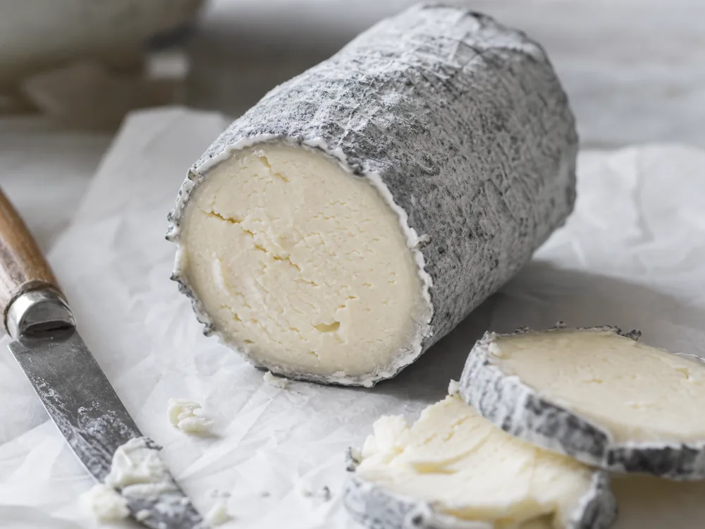 Ash-coated goat cheese log cut face with ivory paste - Aged Chelsea | KnowTheCheese