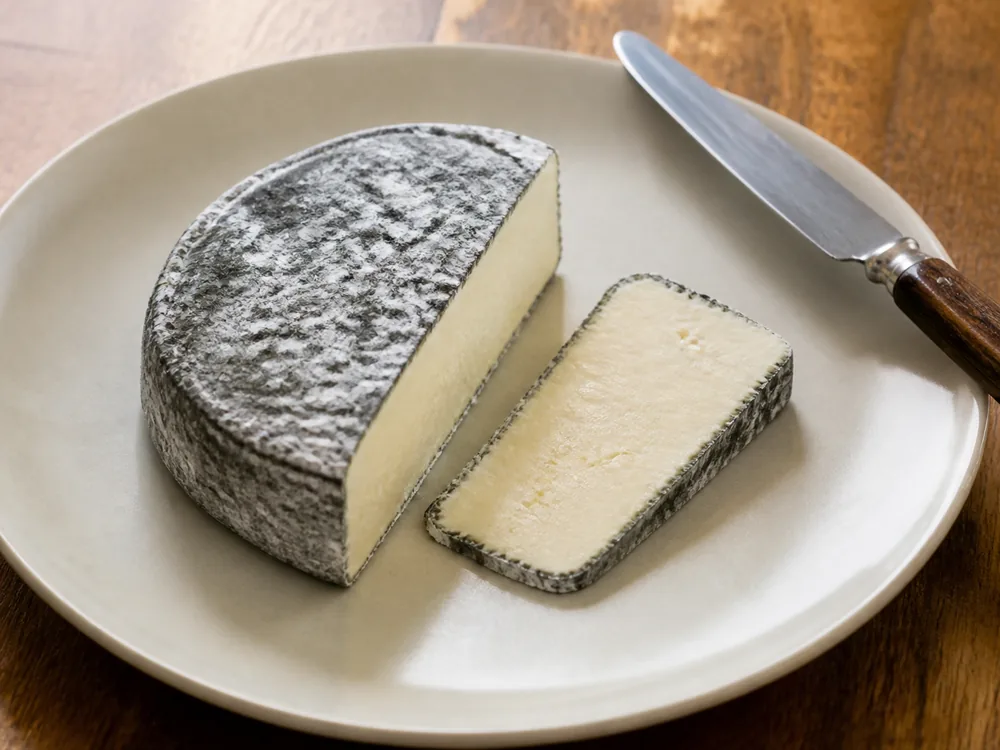 Wedge with one slice cut straight through so ash and paste sit together on the piece - Aisy Cendré | KnowTheCheese