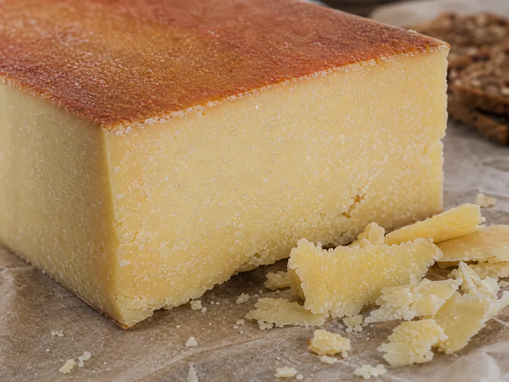 Dense aged Almnäs Tegel-style paste with tiny crystals and reddish rind - Almnäs Tegel | KnowTheCheese