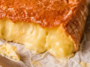 Illustration of an orange washed rind above a soft pale cheese interior