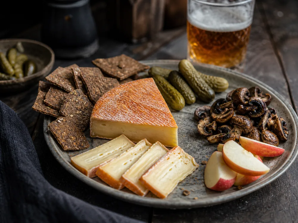 Ameribella-style washed-rind cheese plate with crackers pickles mushrooms and beer - Ameribella | KnowTheCheese