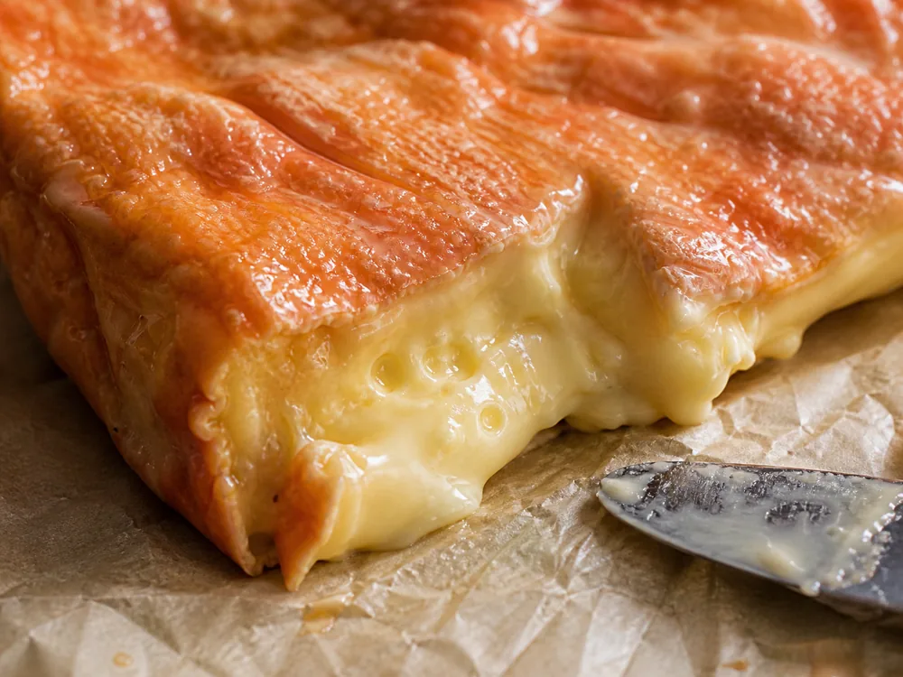 Sticky orange washed rind and custardy paste detail - Ami du Chambertin | KnowTheCheese
