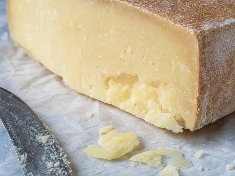 Open flaky hard cheese paste and natural rind detail - Amish Frolic | KnowTheCheese