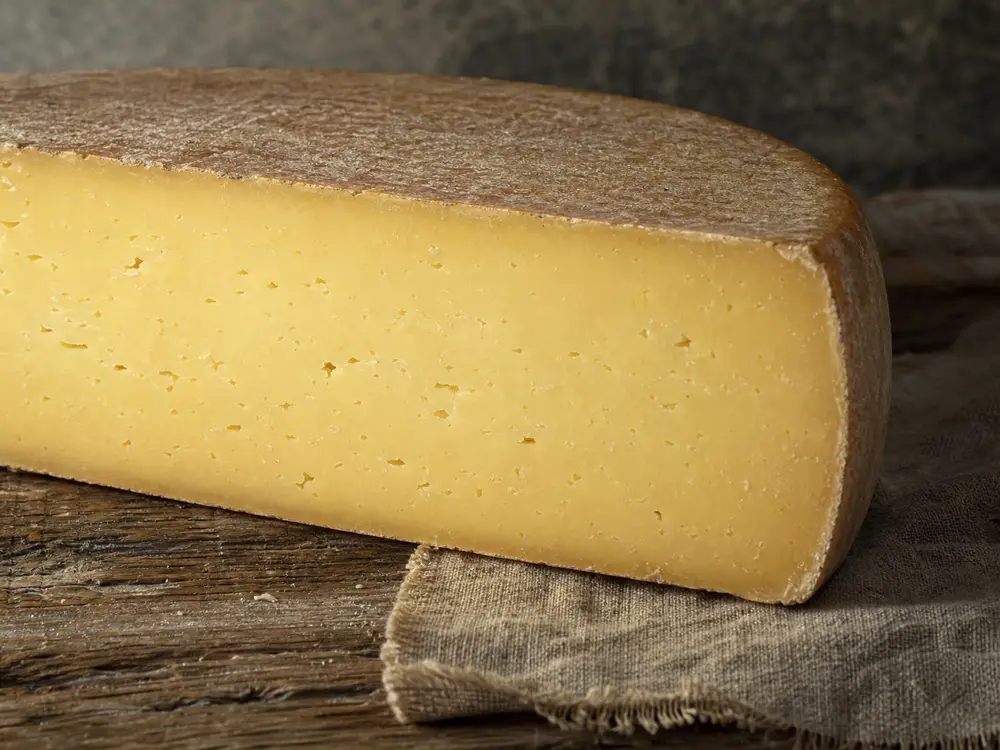 Firm golden sheep cheese paste and thin natural rind detail - Amou | KnowTheCheese