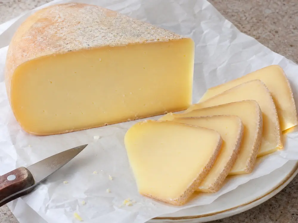 Smooth buttery pale cheese slices and wedge detail - Amsterdammer British Columbia | KnowTheCheese