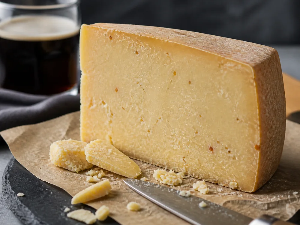 Dense firm cheddar cut face with ale-colored flecks - Anniversary Ale Cheddar | KnowTheCheese