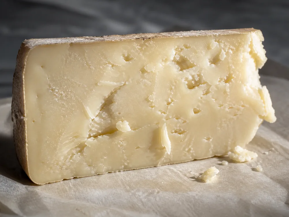 Ivory crumbly farmhouse cheese cut face and fresh flakes - Anster | KnowTheCheese