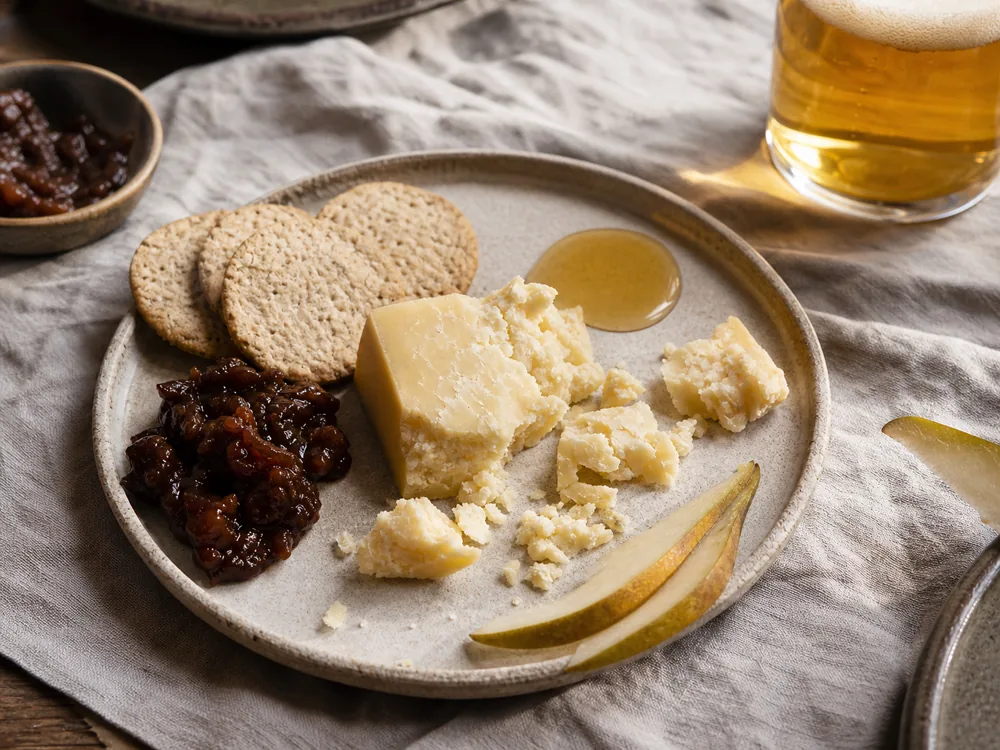 Crumbly Anster-style cheese with oatcakes chutney honey and pale ale - Anster | KnowTheCheese