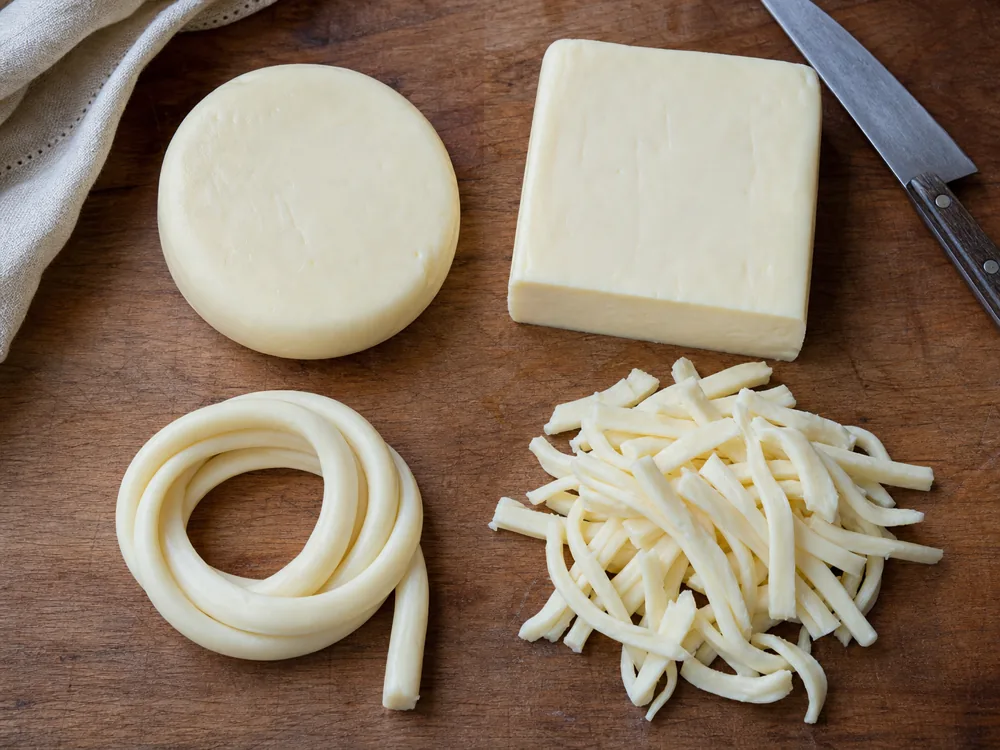 Asadero cheese shown as a round block loose rope and fresh shreds - Asadero cheese | KnowTheCheese