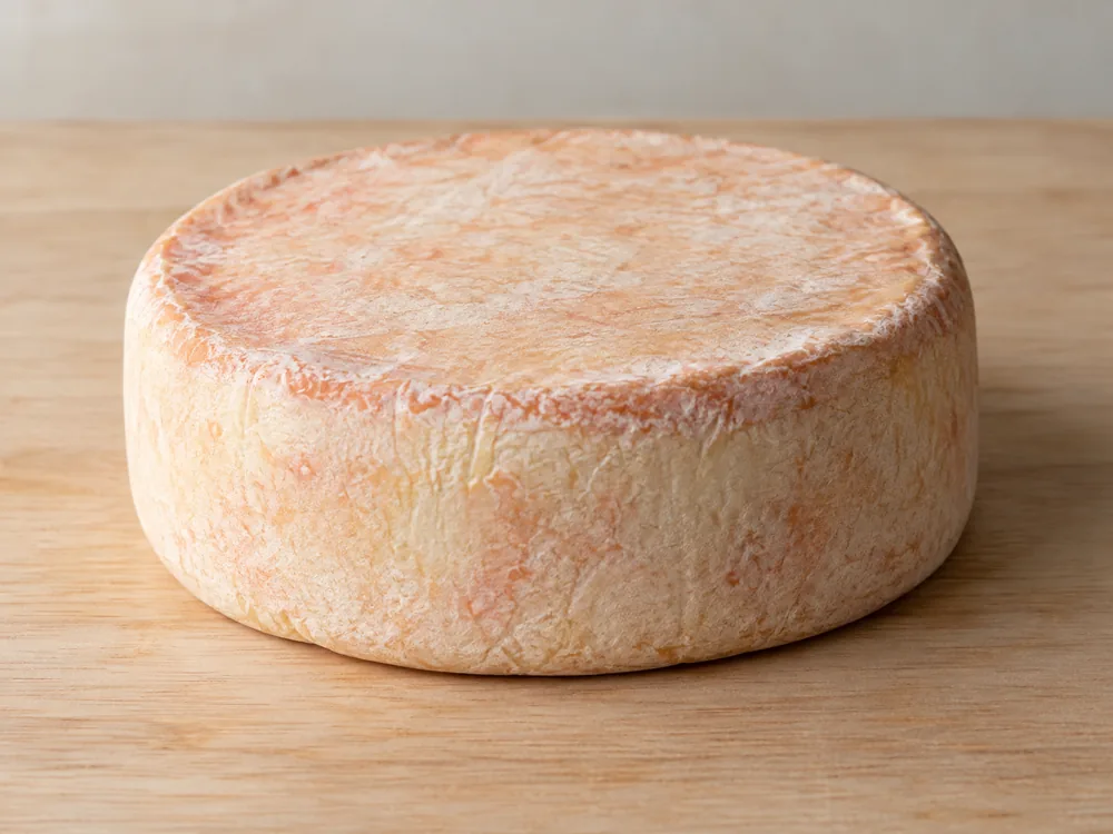 Squat whole wheel of cheese with an off-white natural rind - Asher Blue | KnowTheCheese
