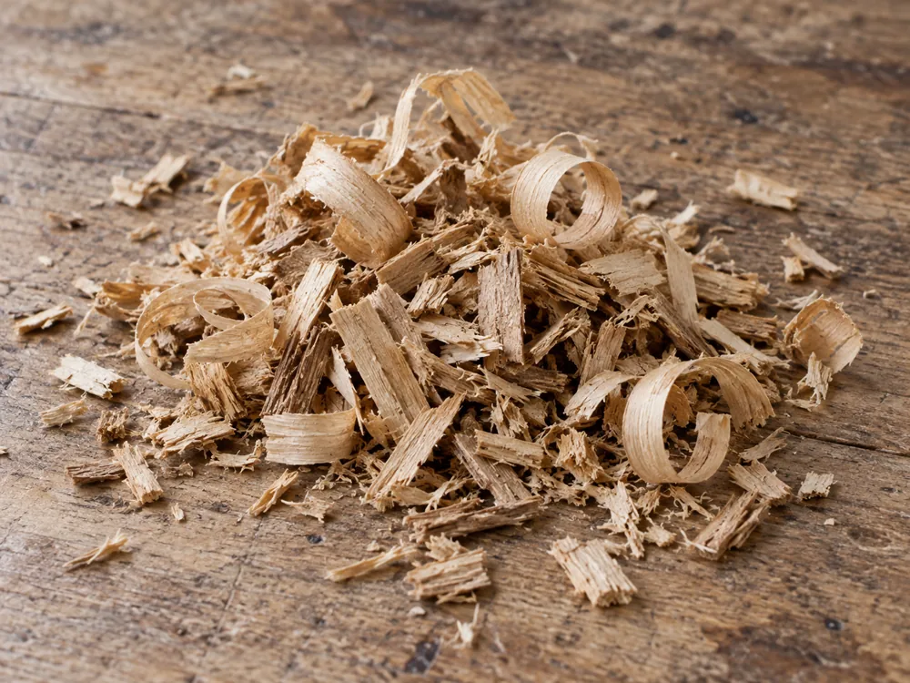 Pile of pale wood shavings on a wooden surface - Auld Reekie | KnowTheCheese