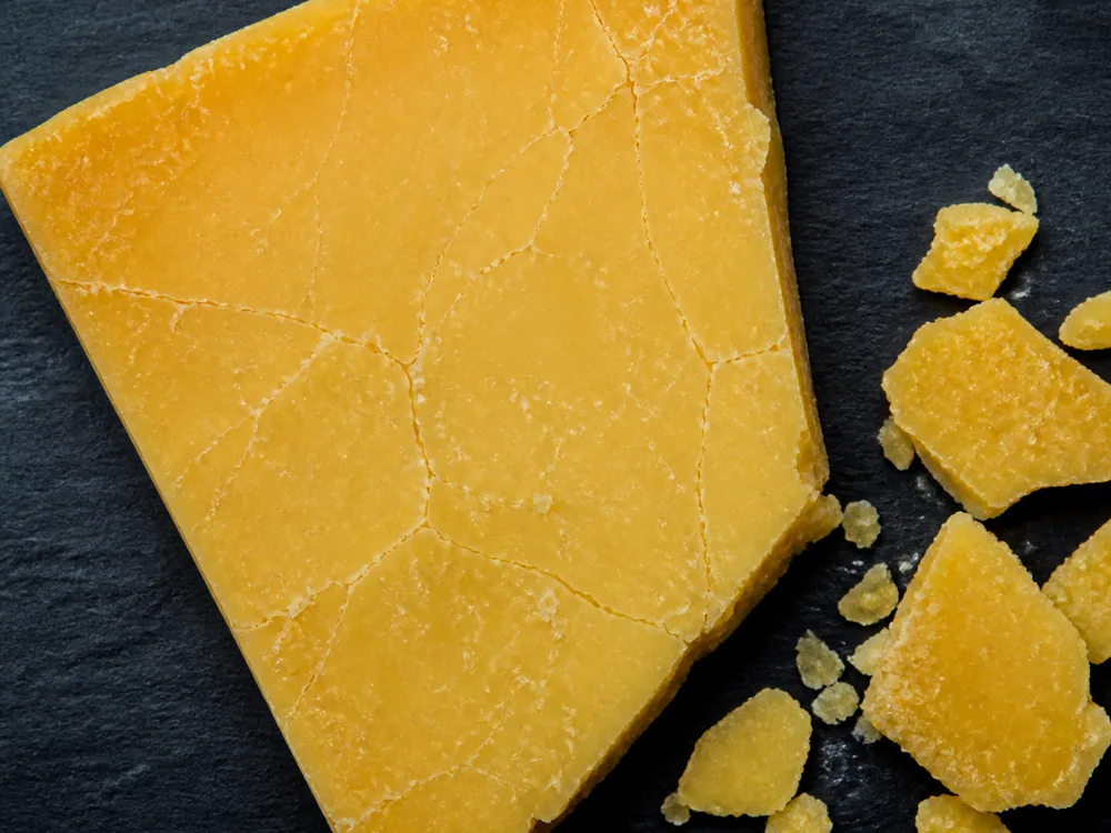 Deep golden paste from above showing fine fracture lines and broken flakes - Avonlea Clothbound Cheddar | KnowTheCheese