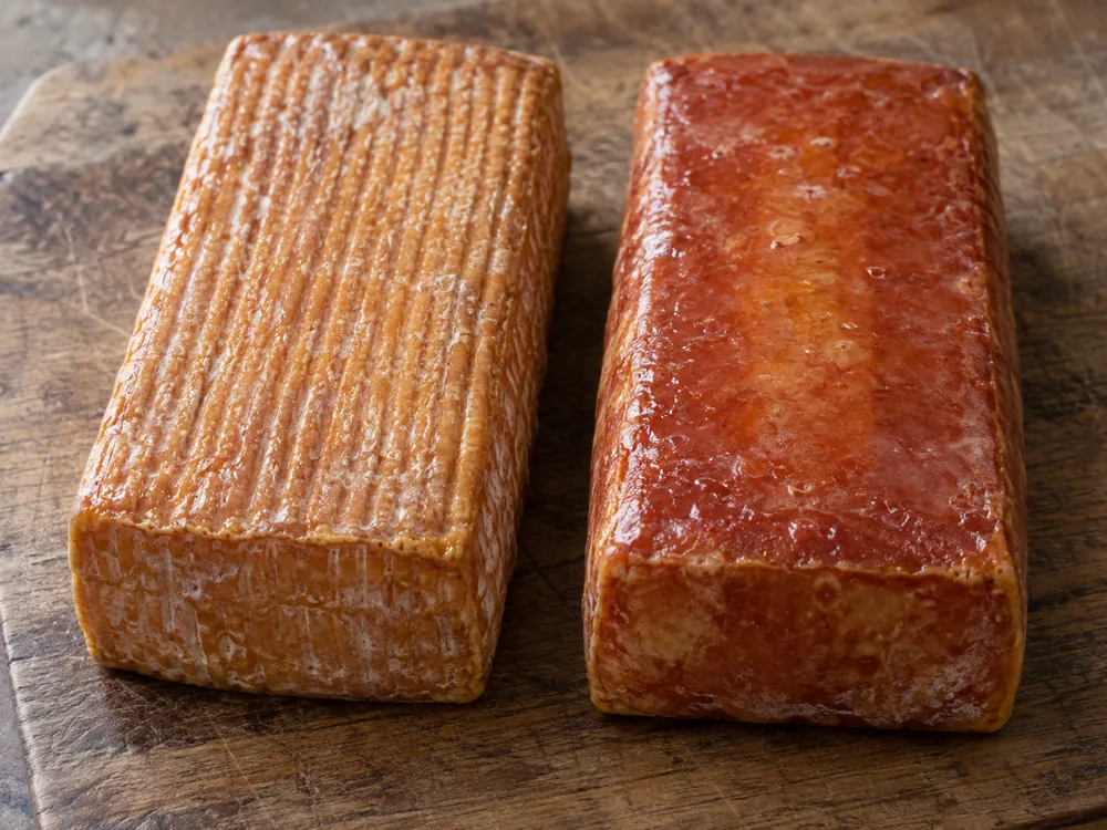 Two bars of washed-rind cheese, one with a striated brown-orange rind and one with a smooth shiny brown-red rind - Baguette laonnaise | KnowTheCheese