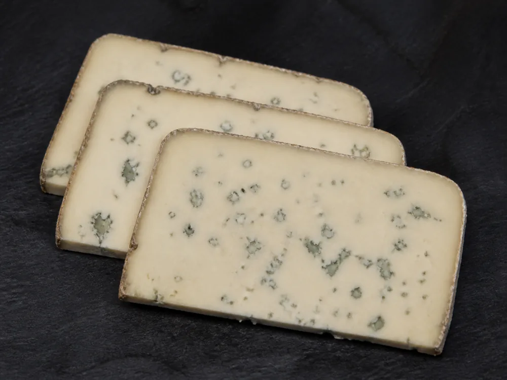 Three clean whole slices of dense pale blue cheese with sharp intact edges and small blue patches - Barden Blue | KnowTheCheese