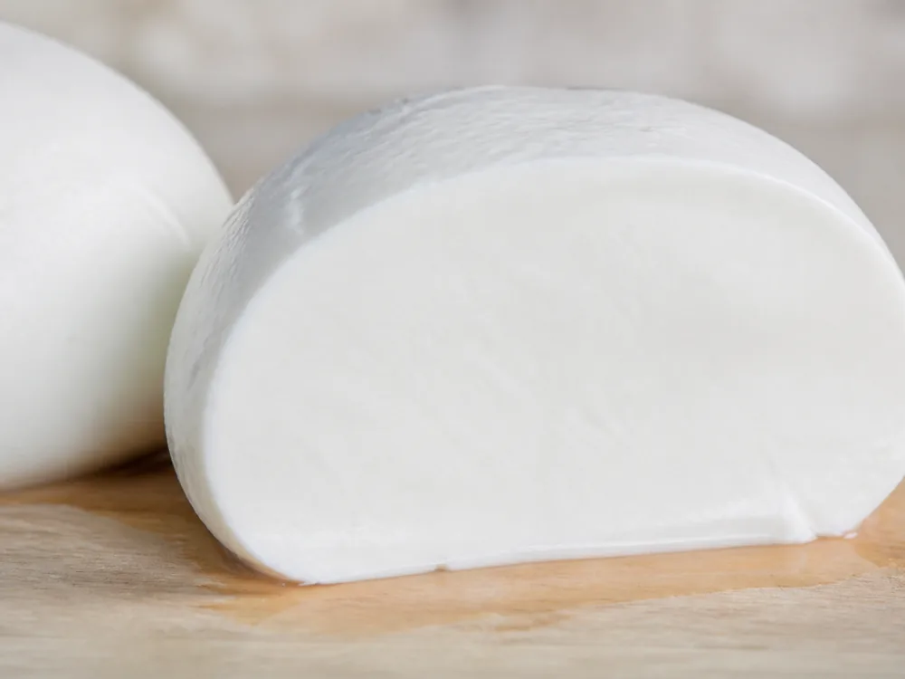 Cut face showing a moist dense white interior with no curd grain and no strands - Basket Cheese | KnowTheCheese