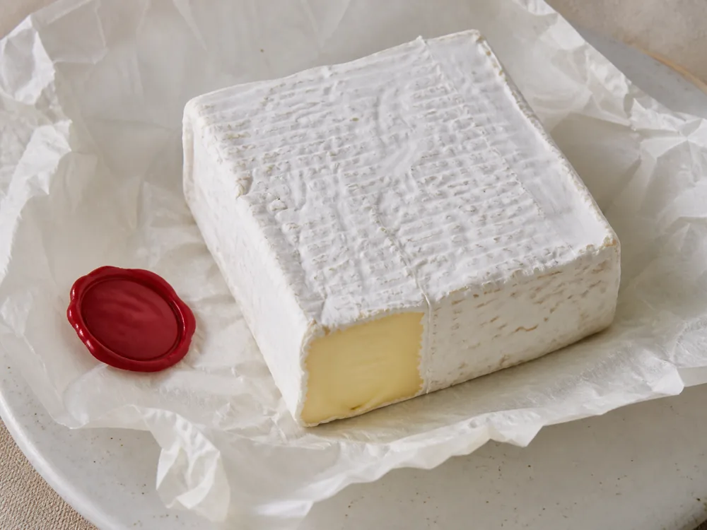 Square Bath Soft-style cheese on parchment with red wax seal - Bath Soft | KnowTheCheese