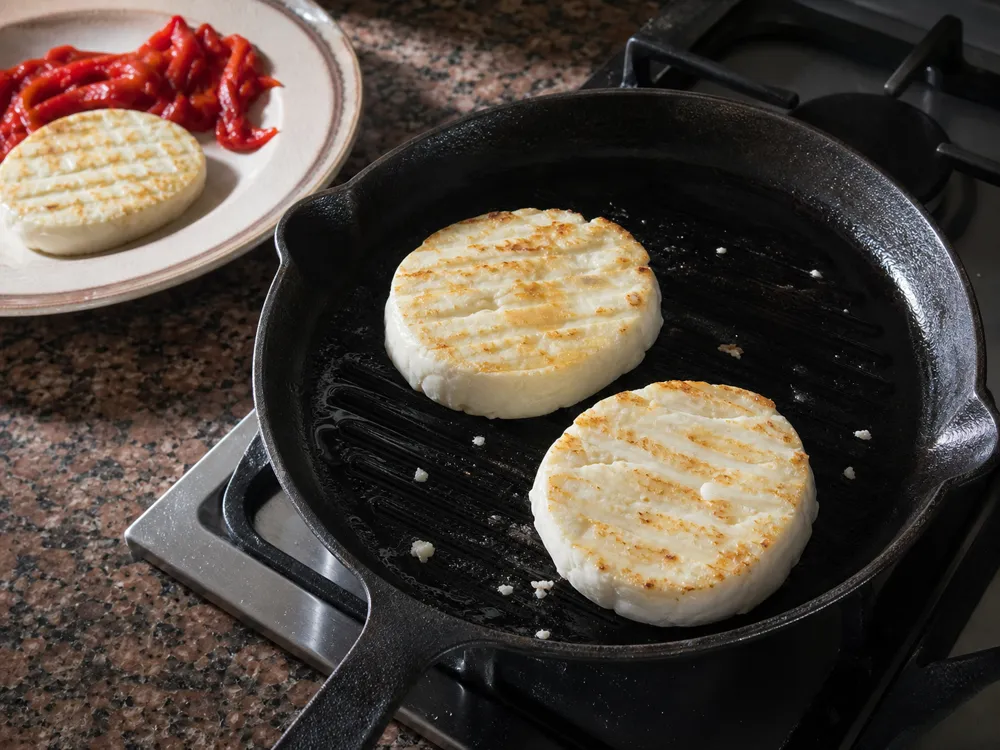 Thick slices of Burgos cheese browning gently on a ridged pan - Burgos Cheese | KnowTheCheese