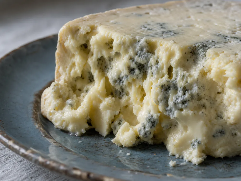 Torn Buttermilk Gorgonzola showing a pillowy paste and blue-gray pockets - Buttermilk Gorgonzola | KnowTheCheese