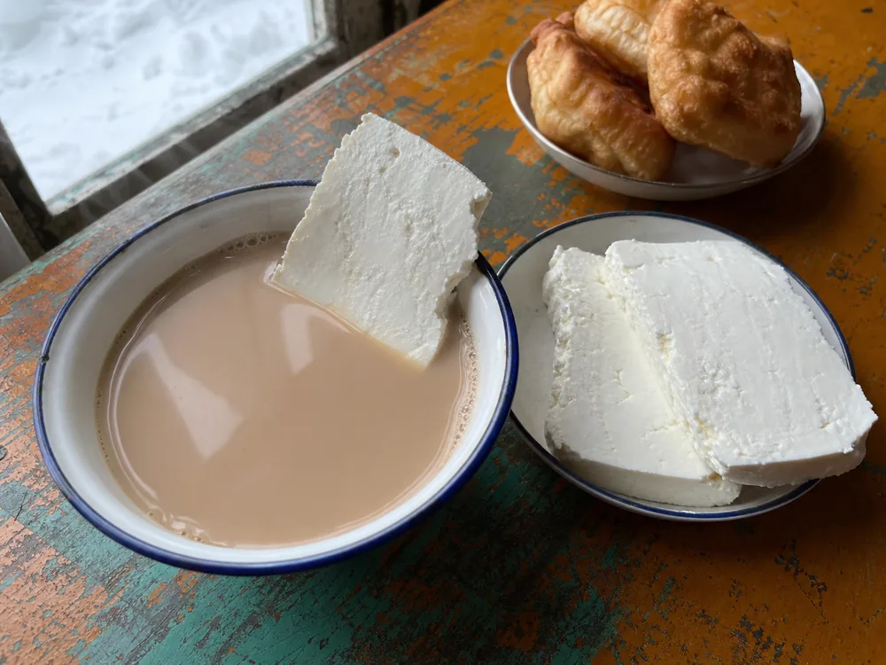 Firm pale cheese slices served with hot salted milk tea - Byaslag | KnowTheCheese