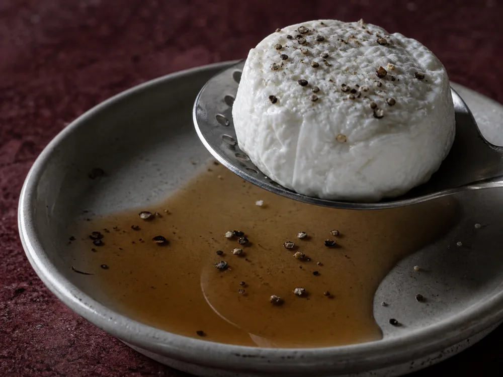 Small goat cheese disc with a light brandy coating and black pepper | KnowTheCheese