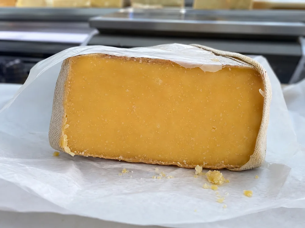 Retail clothbound cheddar wedge with a clean crystalline cut face and dry rind | KnowTheCheese