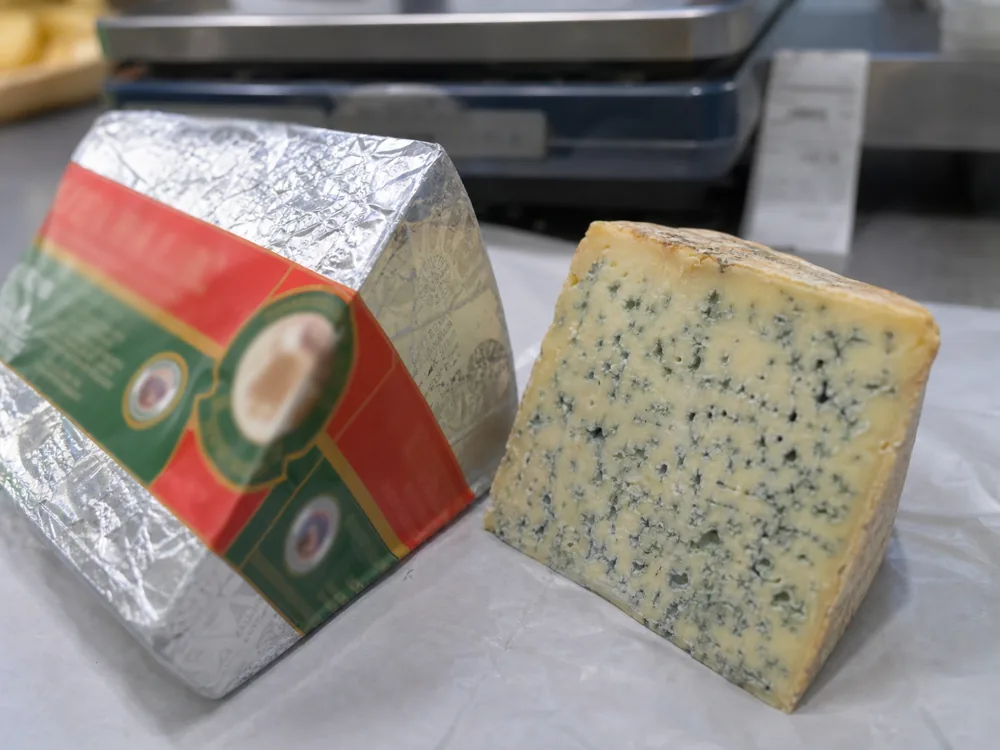 Wrapped and unwrapped blue cheese wedges showing package and paste buying cues | KnowTheCheese
