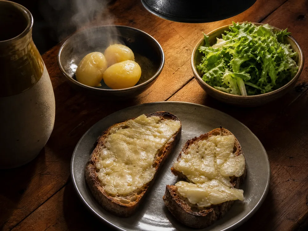 Thin Cachaille spread on hot toast with boiled potatoes and bitter leaves | KnowTheCheese