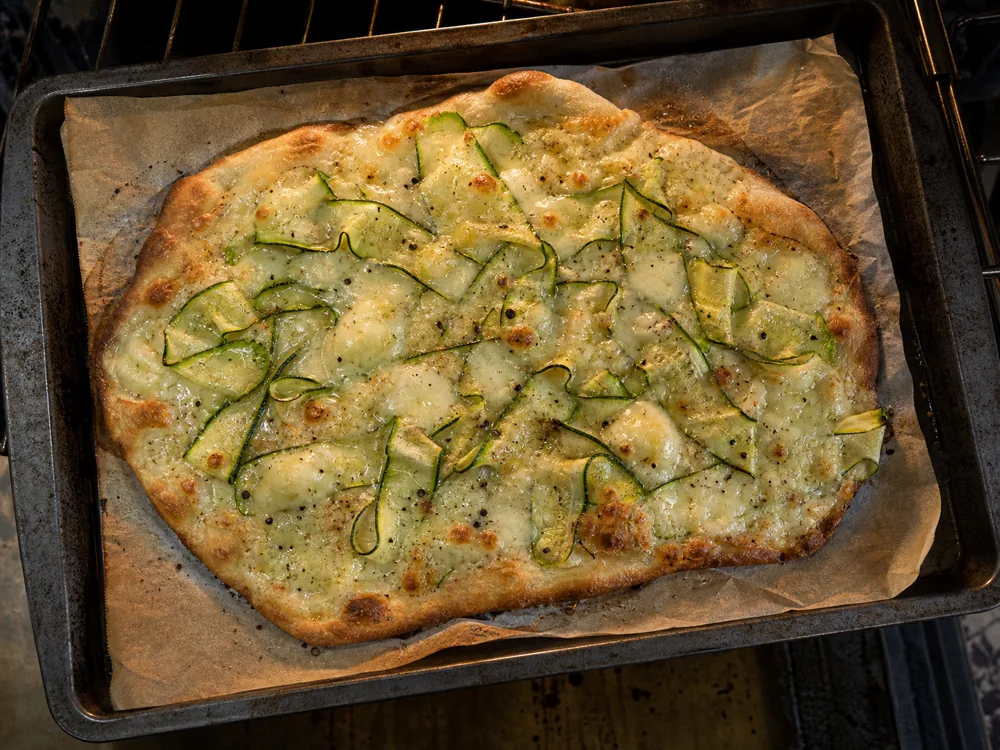 Melted Cacio de Roma on a thin flatbread with courgette | KnowTheCheese