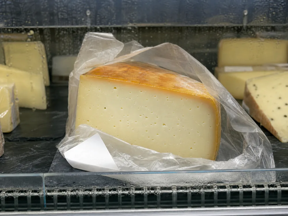 Retail Caciobufala wedge with compact ivory paste and a few small openings | KnowTheCheese