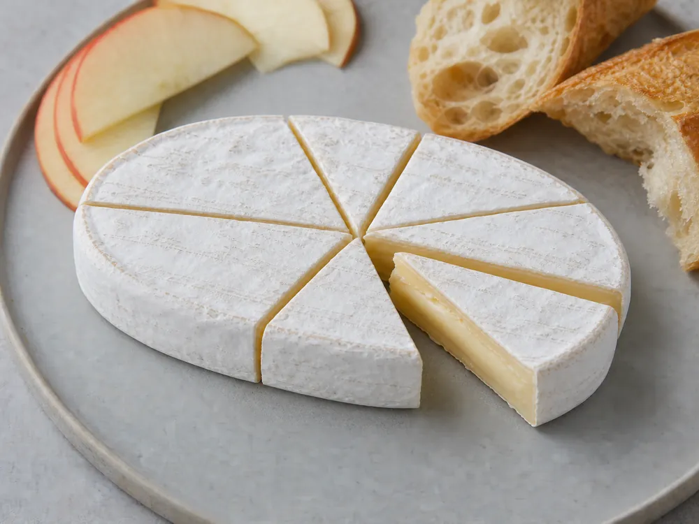 Oval white-rind cheese cut into narrow center-to-edge wedges - Caprice des Dieux cheese | KnowTheCheese
