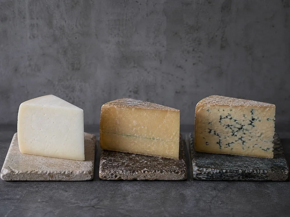 Three Castelmagno-style wedges showing optional blue veining with age | KnowTheCheese