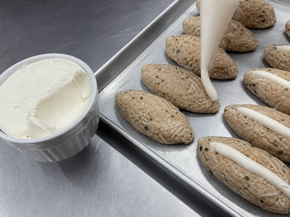 Dense Brazilian requeijao beside chicken croquettes being filled | KnowTheCheese