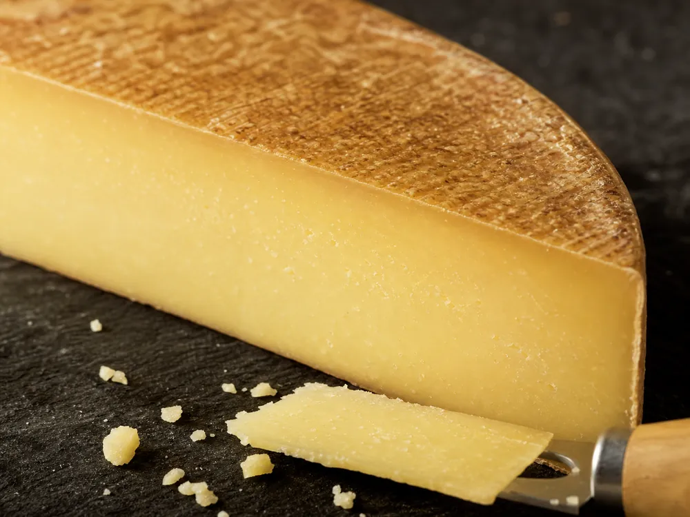 Mature semi-hard Swiss cheese paste and dark brushed rind in close detail | KnowTheCheese