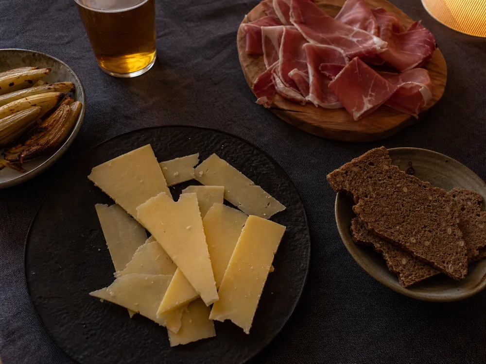 Thin aged Swiss cheese wedges with rye crisps fennel ham and amber beer | KnowTheCheese