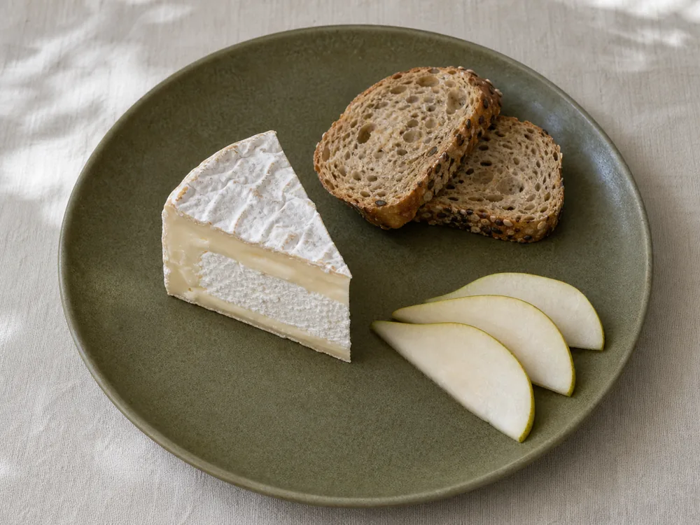 Chaource wedge served with seeded bread and pear - Chaource | KnowTheCheese