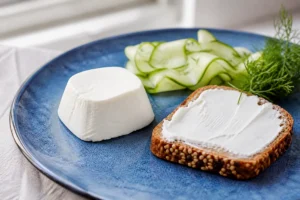 Smooth white fresh goat cheese pyramid with seeded toast and cucumber - Chavroux | KnowTheCheese