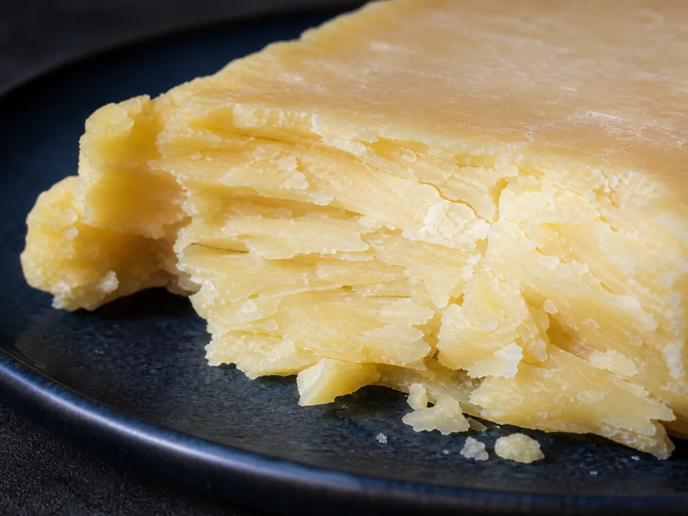 Broken Cheshire cheese showing its moist flaky texture - Cheshire | KnowTheCheese
