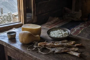 Soft white chhurpi curds and hard dried chhurpi strips on a wooden table | KnowTheCheese