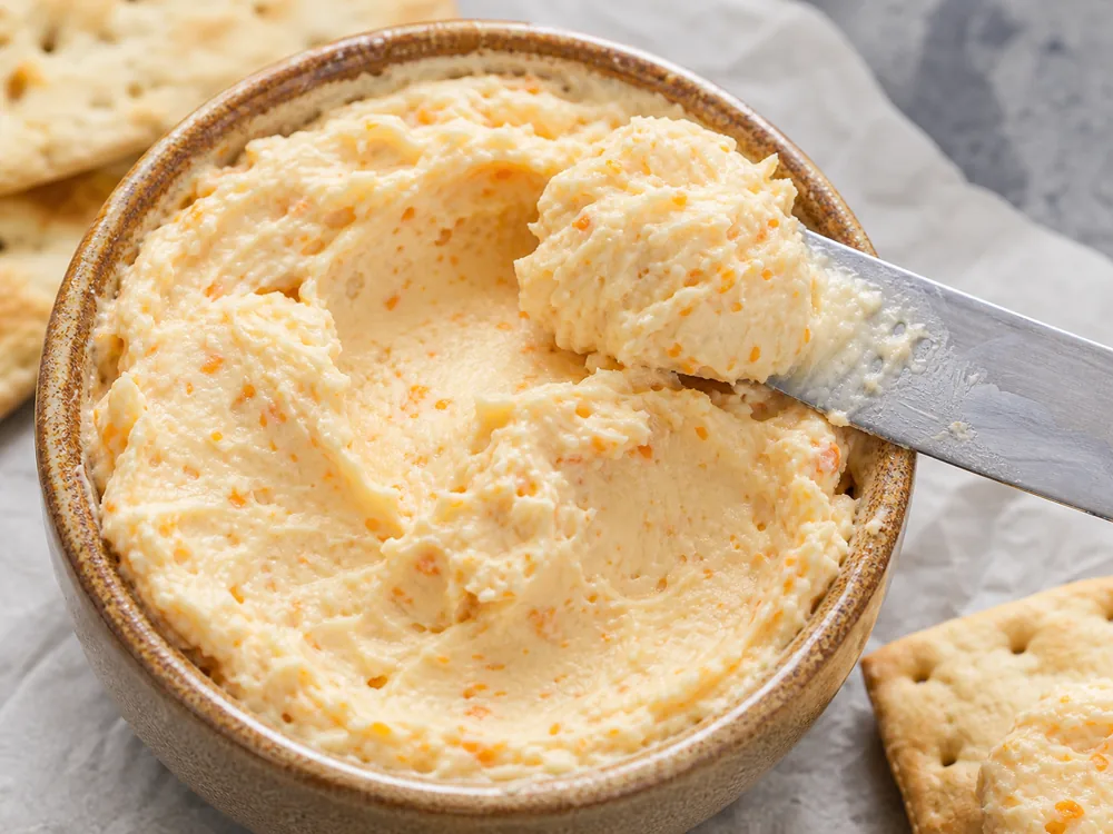 Thick cold pack cheese spread with scoop marks and crackers - Cold Pack | KnowTheCheese