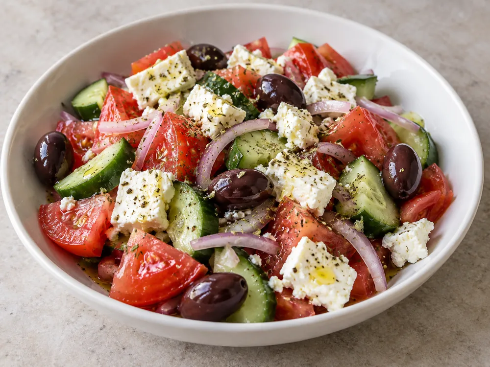 Greek salad of tomato, cucumber, onion, olives and feta with oregano and olive oil - Goat Cheese vs Feta | KnowTheCheese