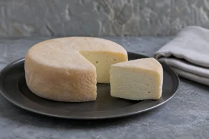 Cotherstone wheel and wedge with pale crumbly paste and thin rind | KnowTheCheese