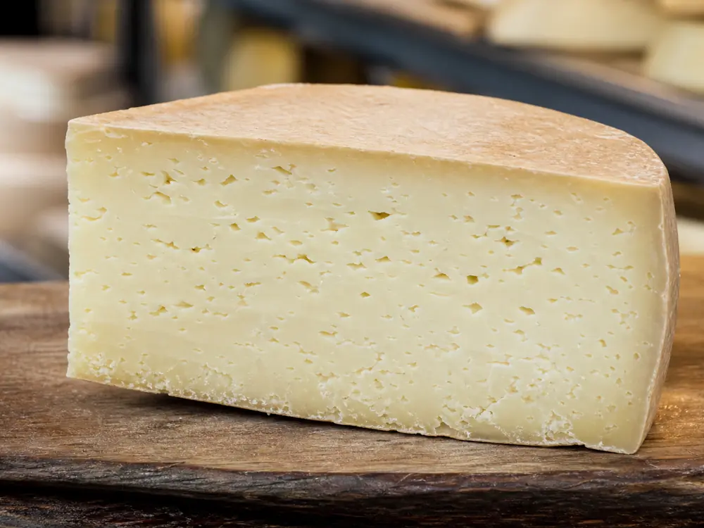 Fresh cut Cotherstone with pale paste, fine openings, and a thin natural rind