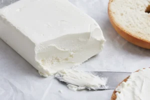 Soft white block of fresh cream cheese with a knife swipe - cream cheese | KnowTheCheese
