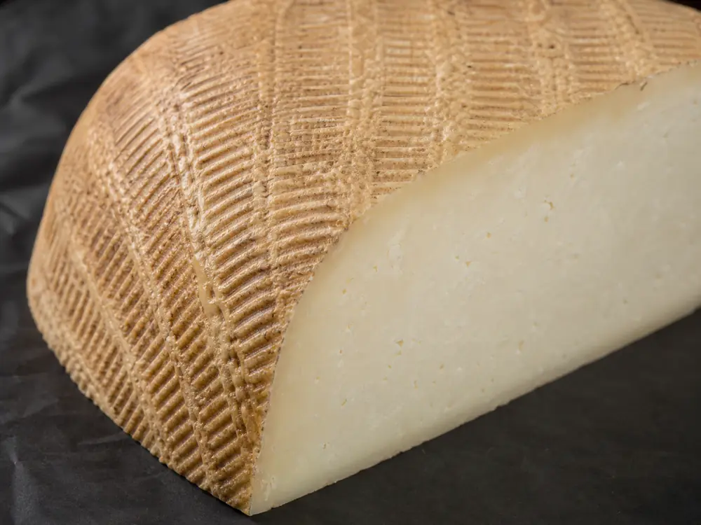 Basket-weave rind and compact pale paste on a sheep milk wheel - Pecorino Crotonese | KnowTheCheese