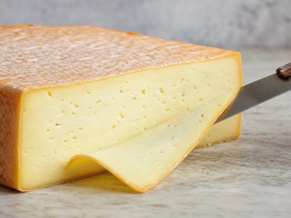 Cut Danbo cheese block with washed rind and pale springy paste - Danbo | KnowTheCheese