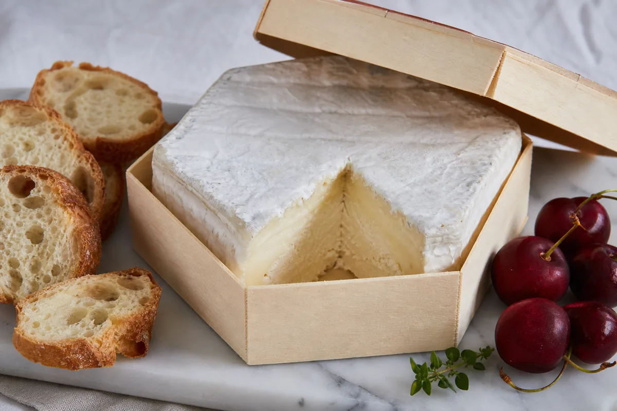 Dauphin soft cheese in a wooden box with baguette and cherries - Dauphin | KnowTheCheese