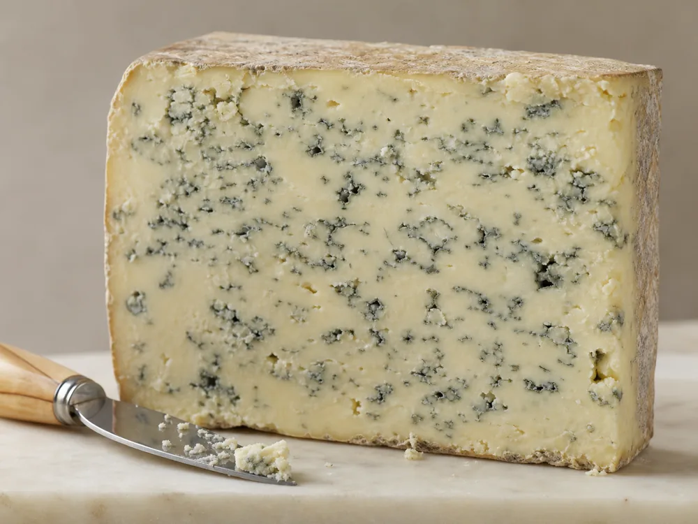 Close cut Devon Blue cheese showing dense paste and fine blue veining - Devon Blue | KnowTheCheese