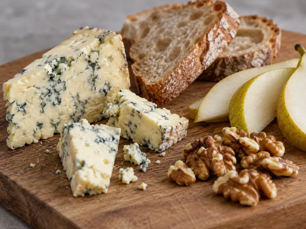 Blue-veined cheese pieces with bread, pear slices and walnuts - Devon Blue | KnowTheCheese