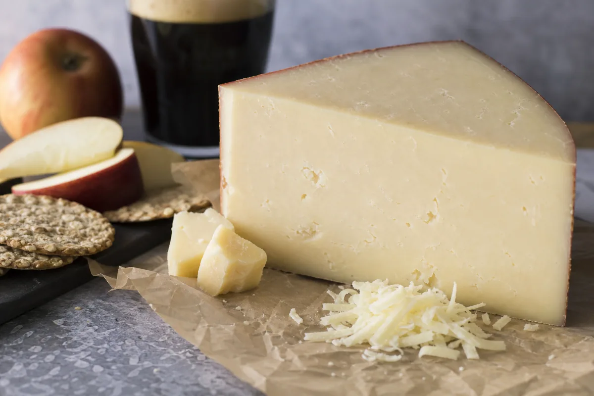 Doddington cheese wedge with apples oat crackers and ale - Doddington | KnowTheCheese